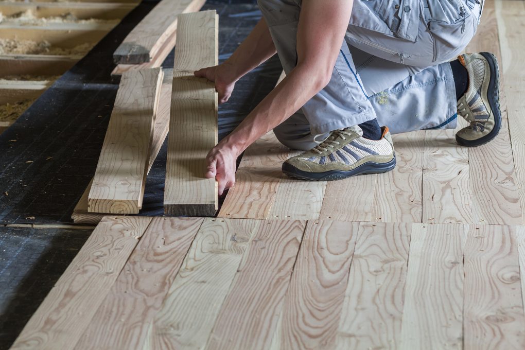 Charpentier posant un plancher bois naturel - travaux P&M Charpente